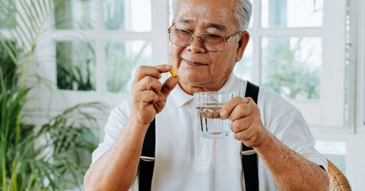 Nejlepší doplňky stravy na klouby pro seniory: Jak udržet pohyblivost v pozdním věku 4 an elderly person taking a dietary supplement for joint health with a glass of water