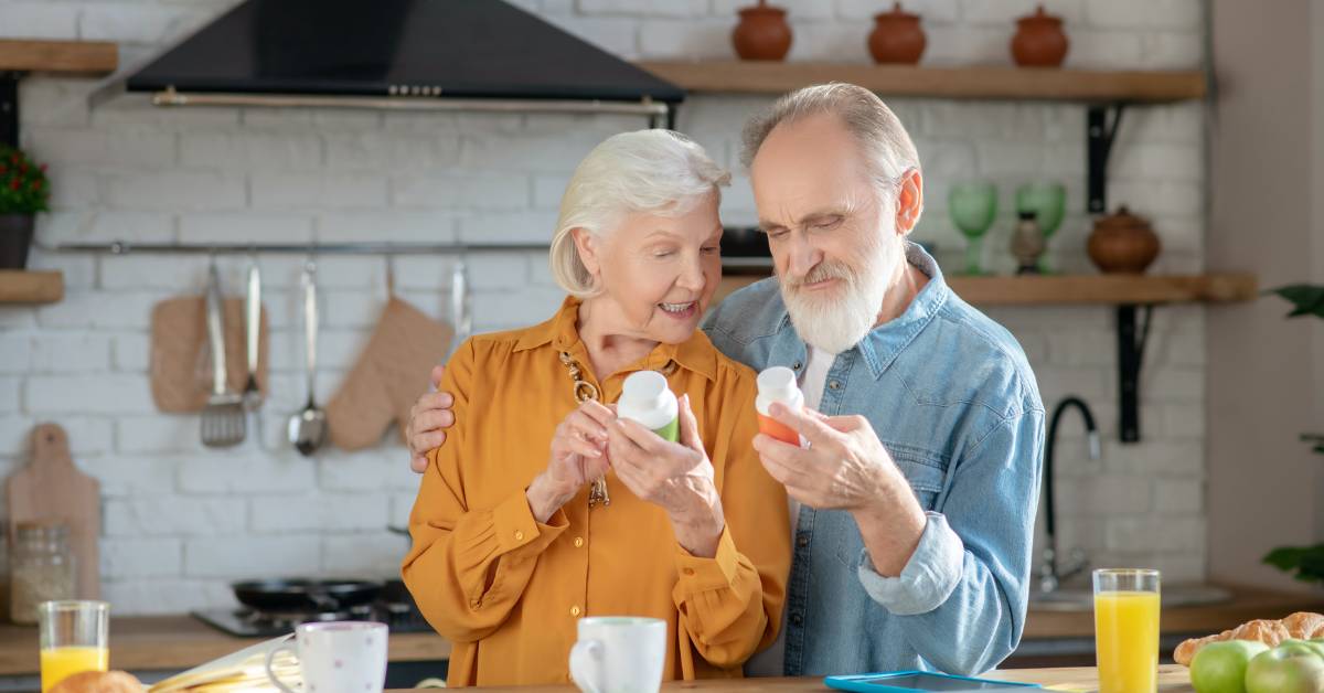 10 Nejlepších vitamínů pro seniory: Doporučené přípravky a jejich výhody 6 senior couple happily examining vitamin supplements, possibly vitamin D and B12, at a bright kitchen counter.