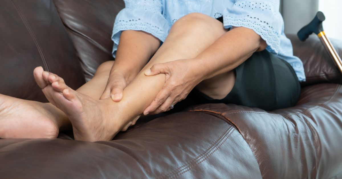 Babské rady na křeče v nohách: 12 Tipů jak si s nimi poradit! 1 a person gently massaging another’s feet while sitting on a couch, focusing on relaxation and potential relief of muscle tension.