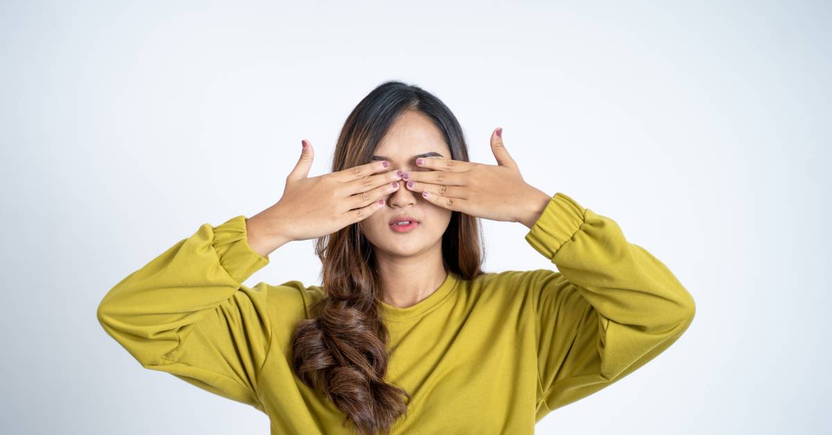 a person demonstrating the palming technique for eye relaxation and muscle relief by gently covering closed eyes with cupped hands